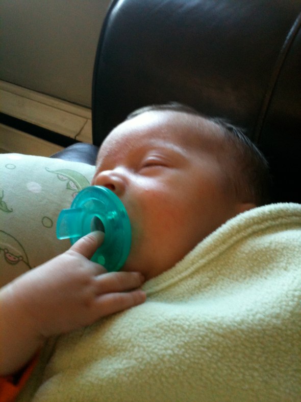 Henry holds his pacifier in